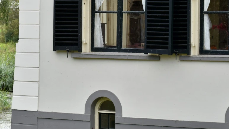 A white house with black shutters and windows